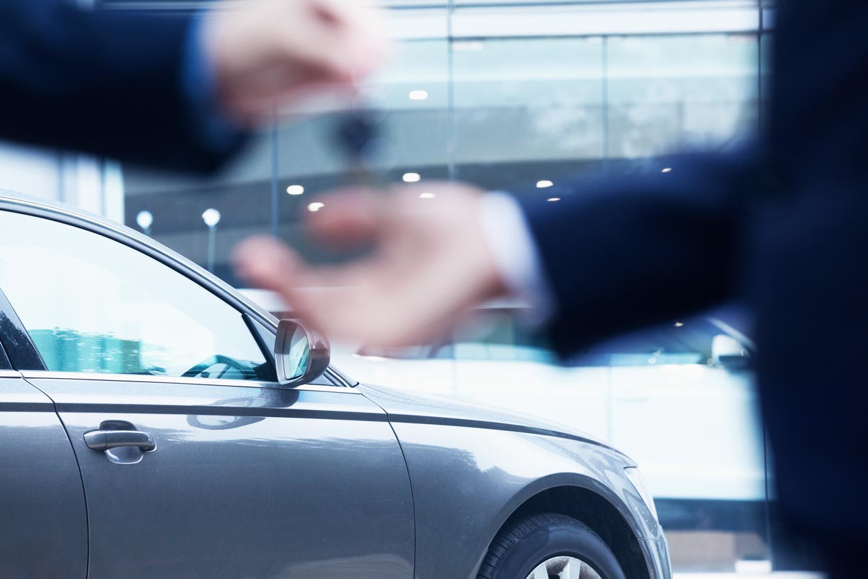 Car dealer handing over the keys to car bought on finance