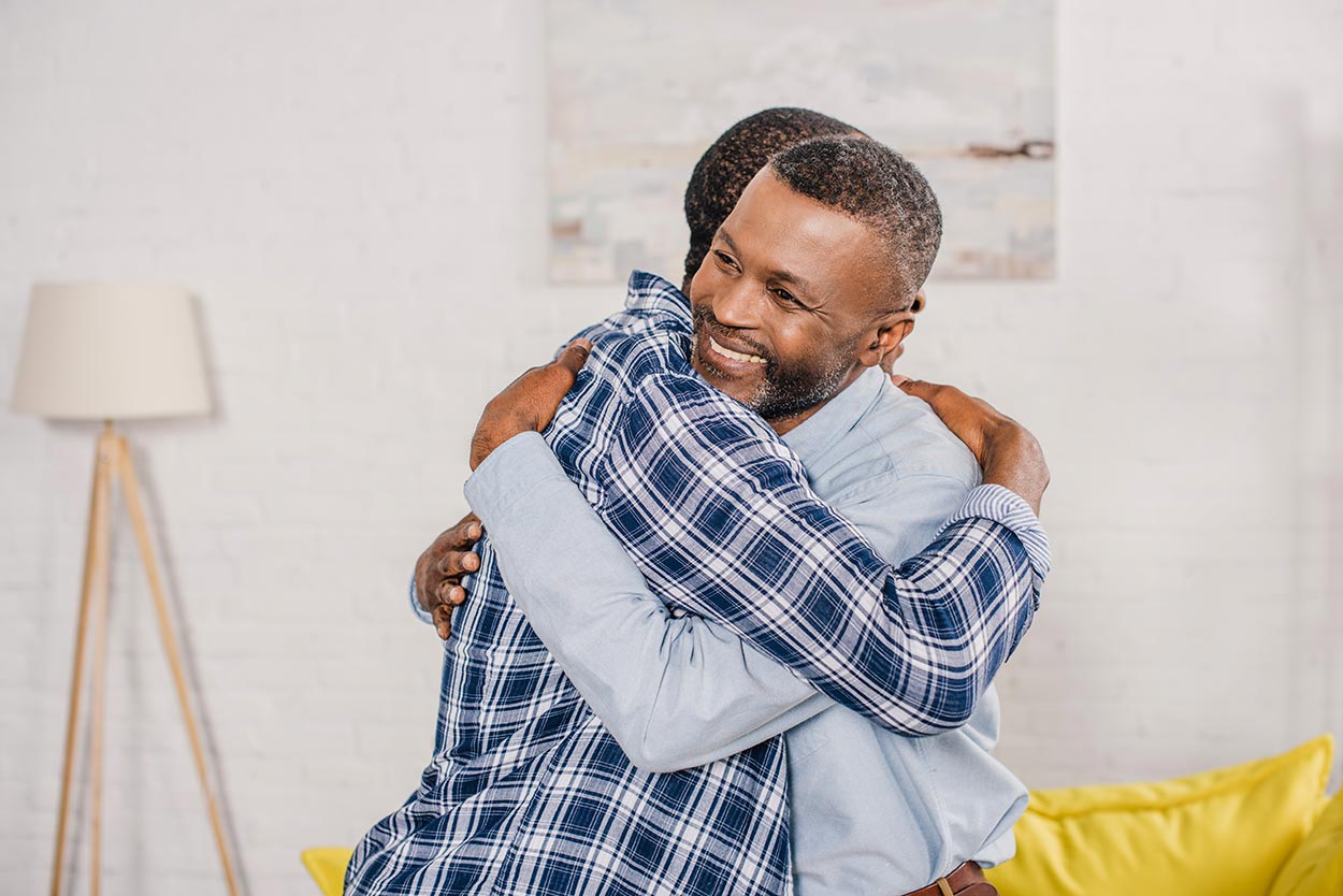 Man hugging his dad after securing a guarantor loan