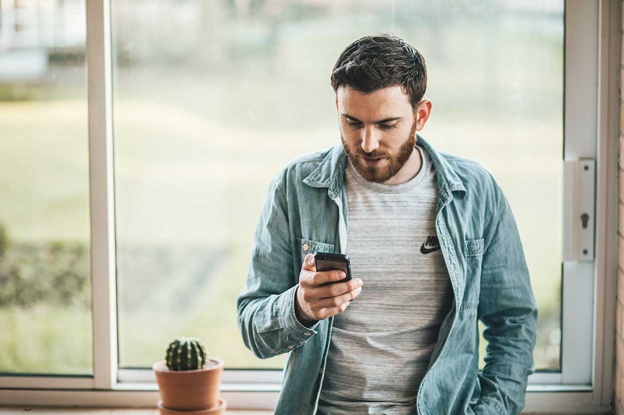 Man using phone to research how to build your credit score in your thirties