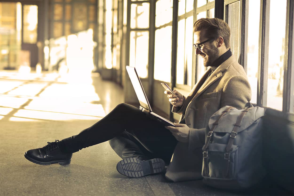 Man sat looking at phone researching how to get an excellent credit score