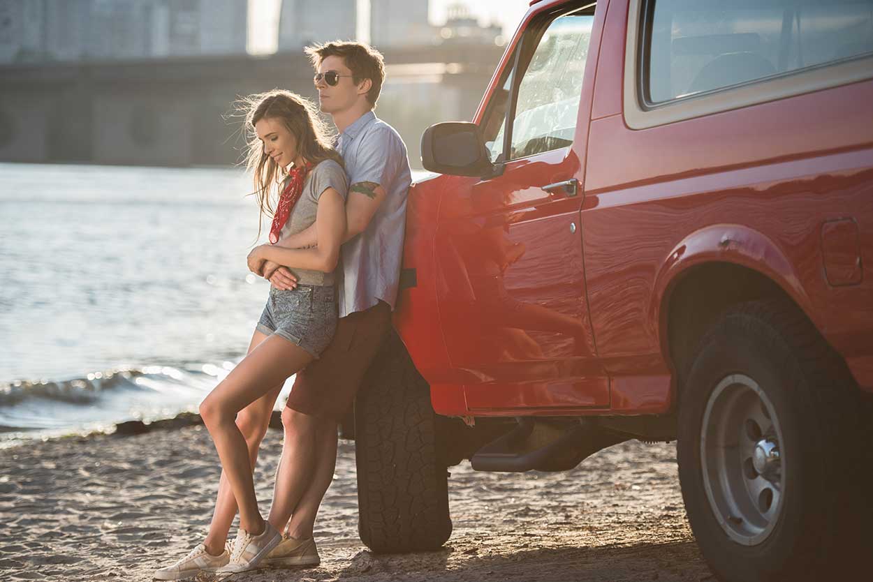 Couple leaning against red 4X4 wondering about their credit score range