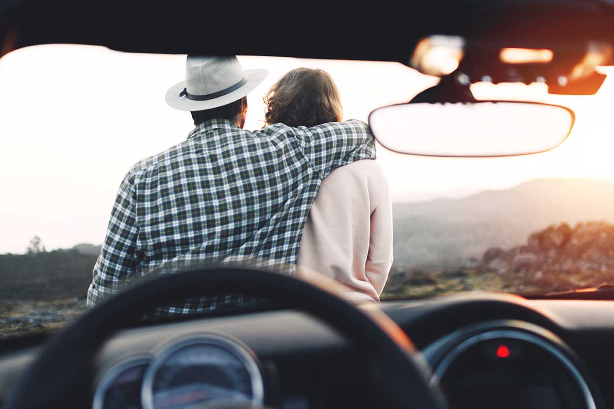 couple sitting on car bonnet whilst coming up with names for your car