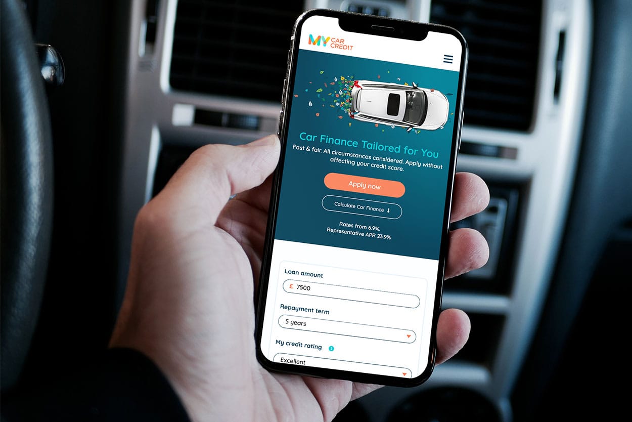 man holding mobile phone showing new car finance website my car credit