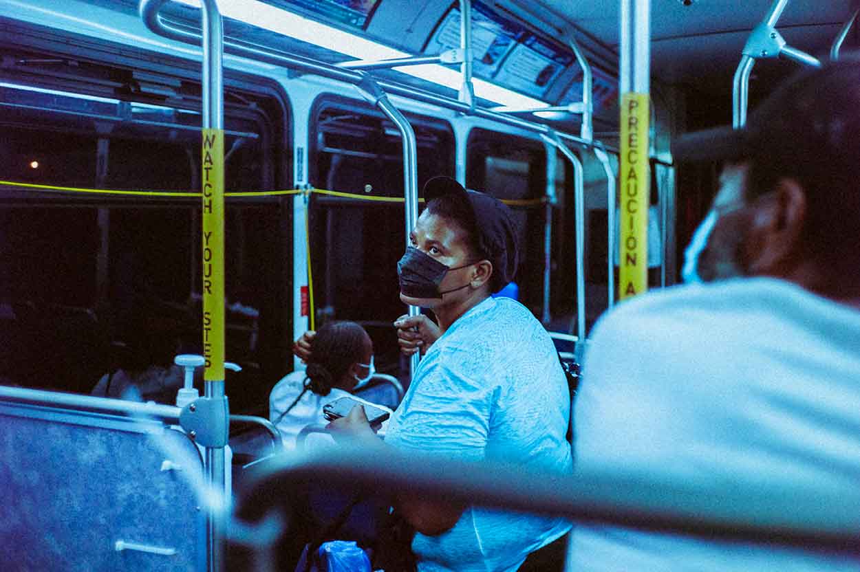 man on public transport wearing a mask thinking of buying a car on finance