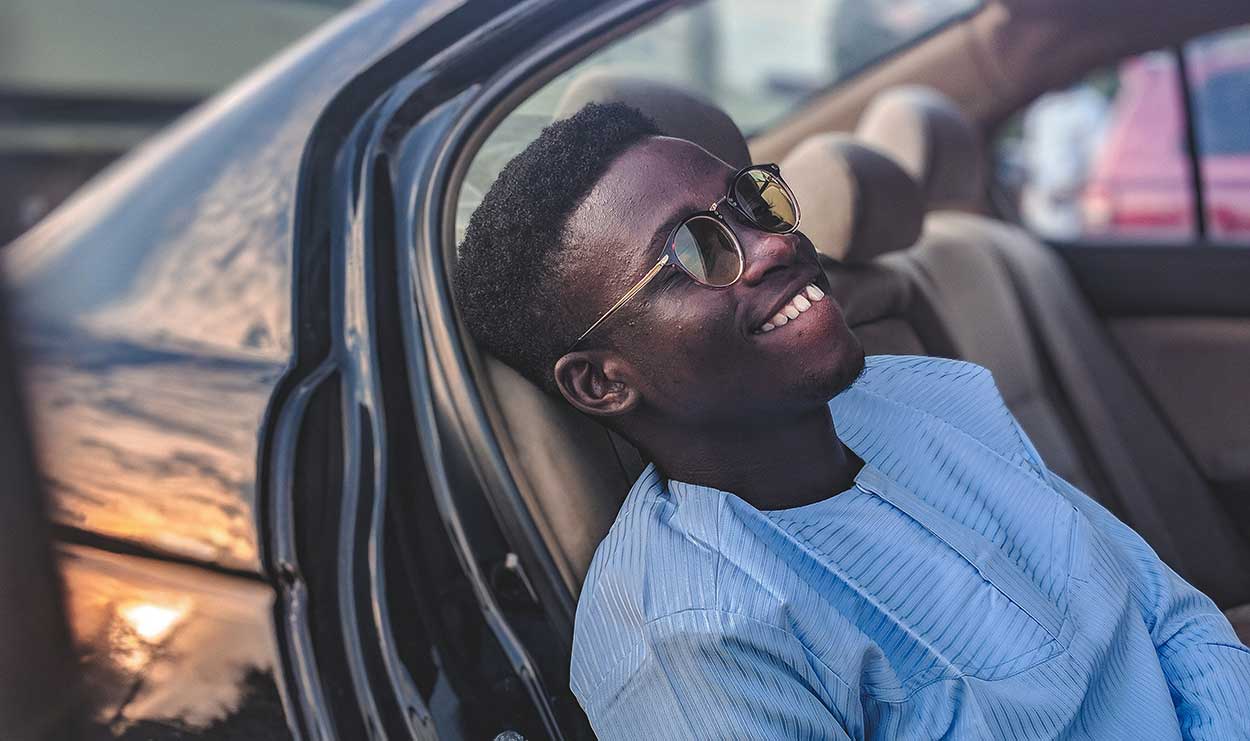 man smiling whilst thinking about buying your first car