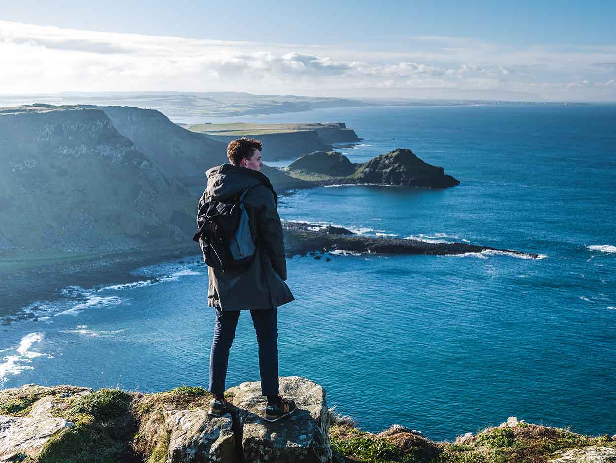 man on staycation standing on cliff overlooking giants causeway