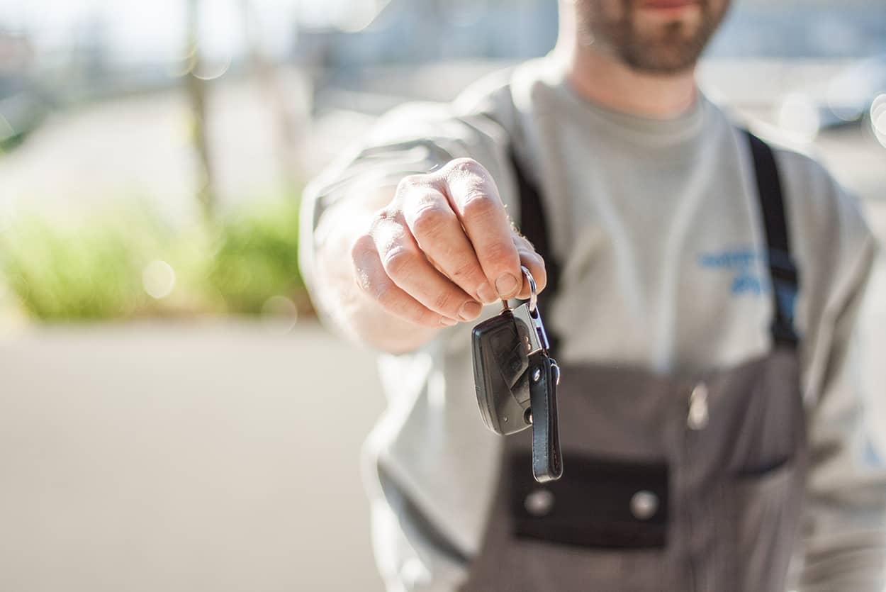 Man handing over car keys after clearing outstanding finance on his car