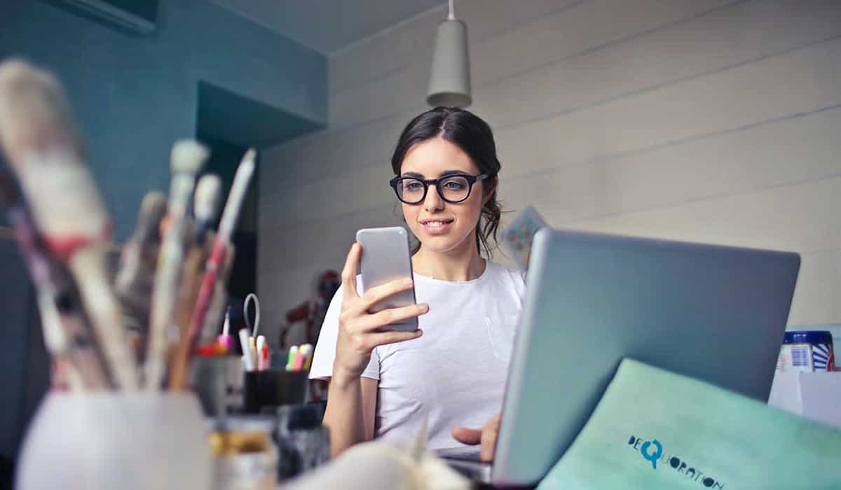 Woman at work checking her credit profile on her phone