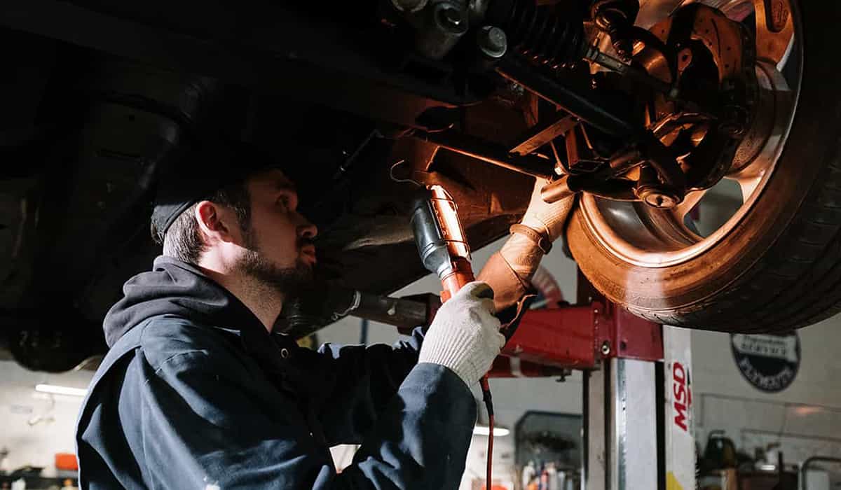 Mechanic inspecting a car which falls under one of the write off categories