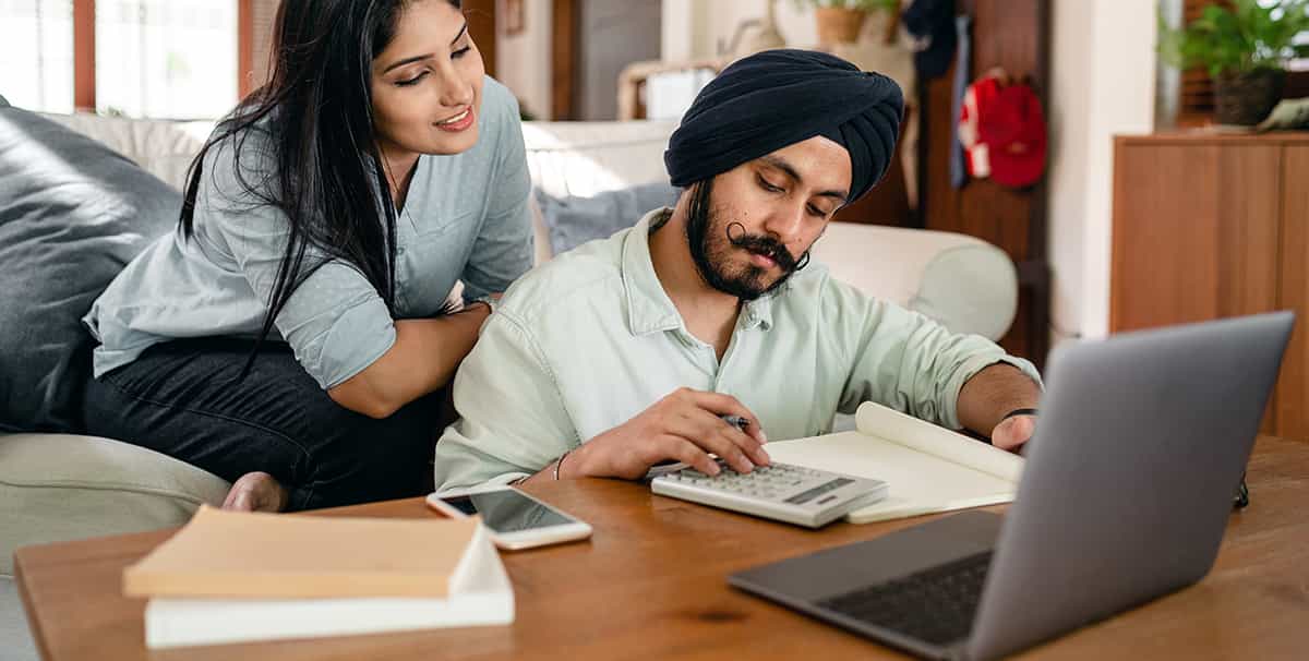 Couple using a calculator to work out car finance