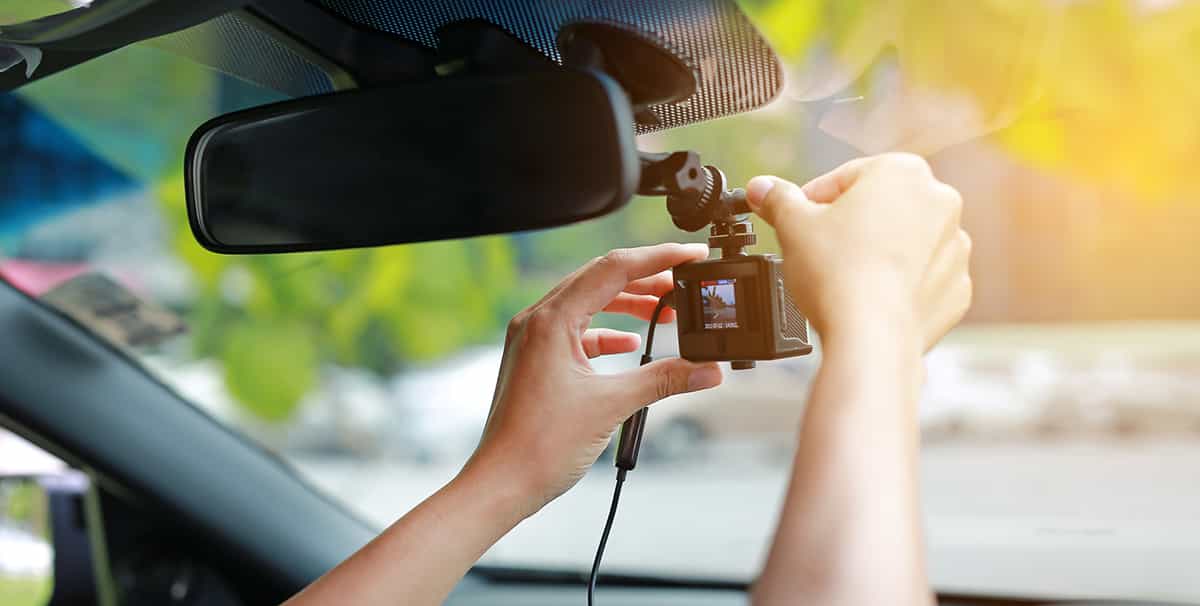 person installing a dash cam in their car