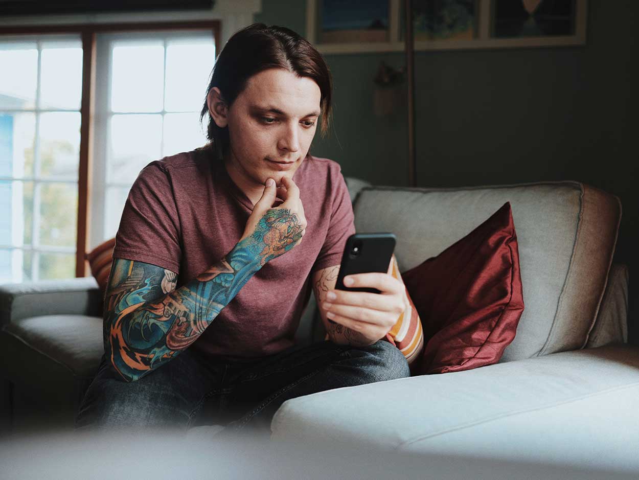 Man using his phone to calculate his cost of car ownership