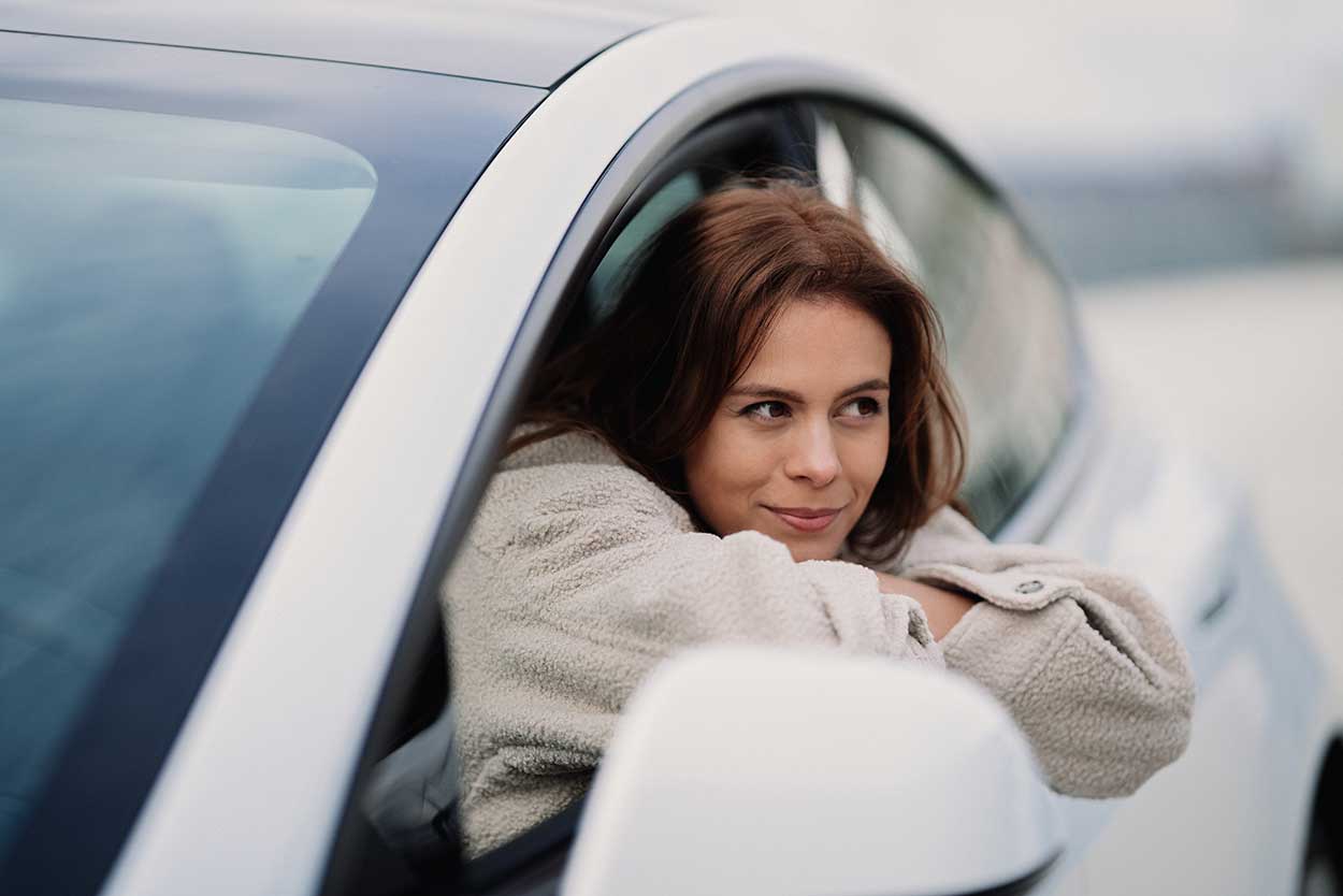 woman in white car wondering how do self driving cars work