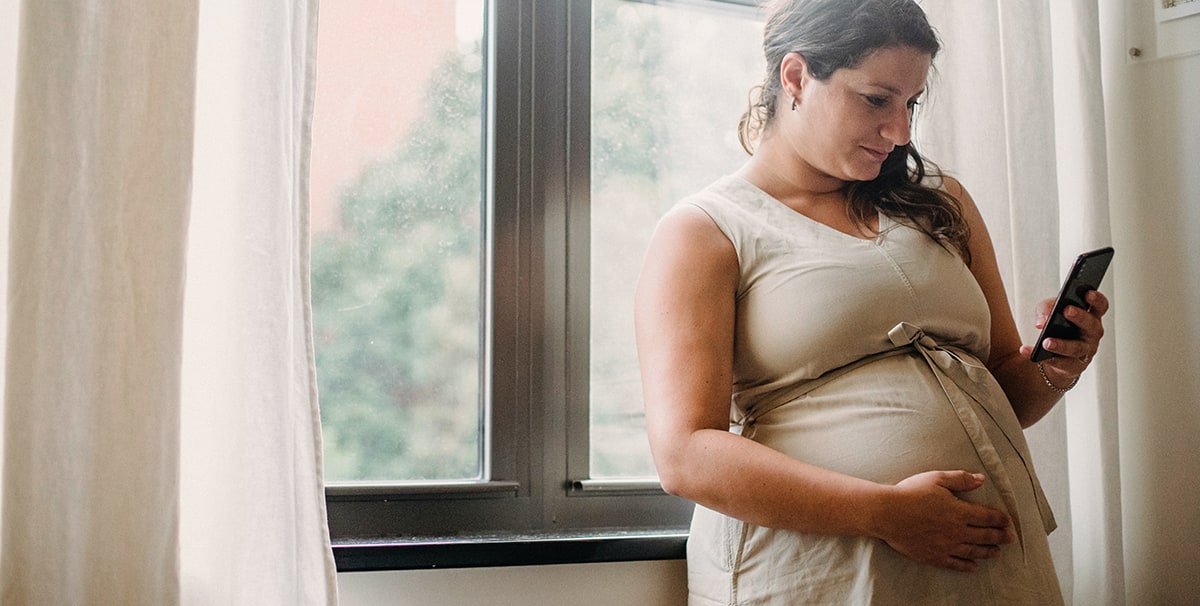 Pregnant lady using phone to find a car