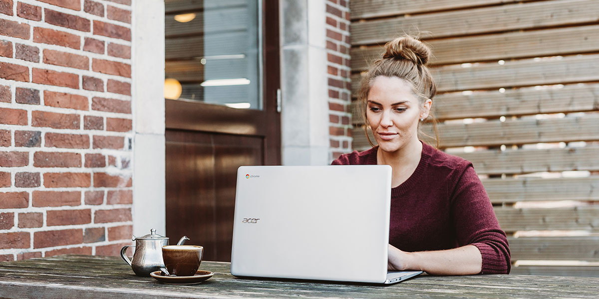 Woman sat outside on laptop