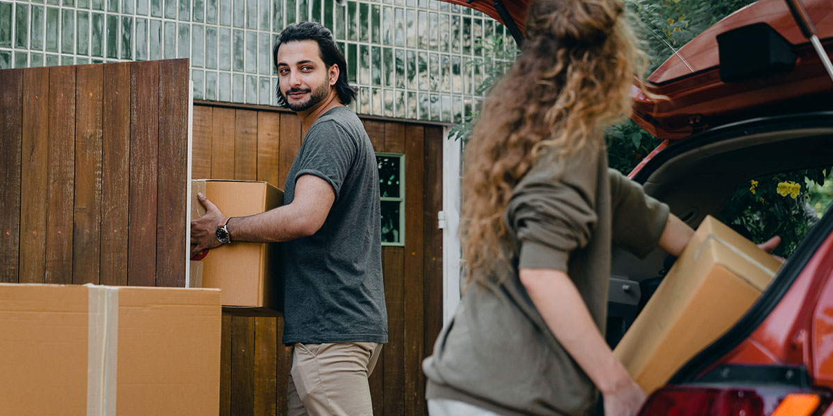 Couple unloading car and moving into a new house