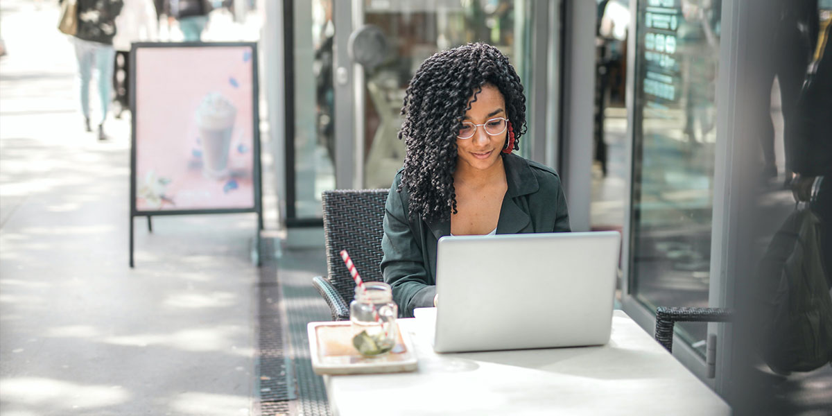 Woman on laptop outside a cafe