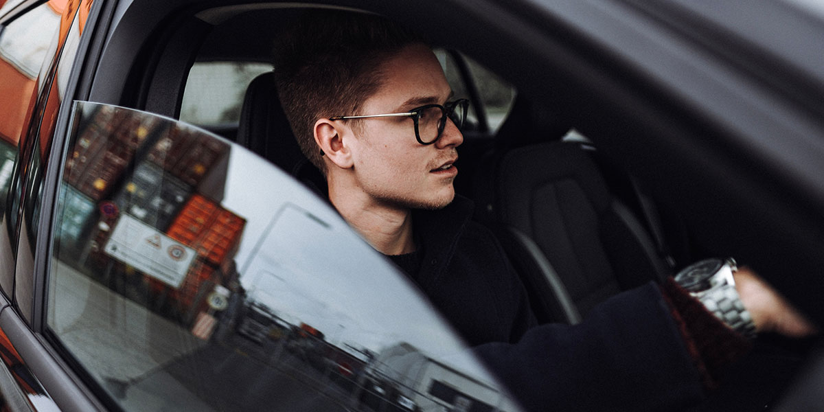 Young man driving car with window down