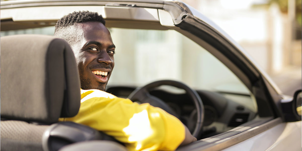 Manin yellow top in a convertible car