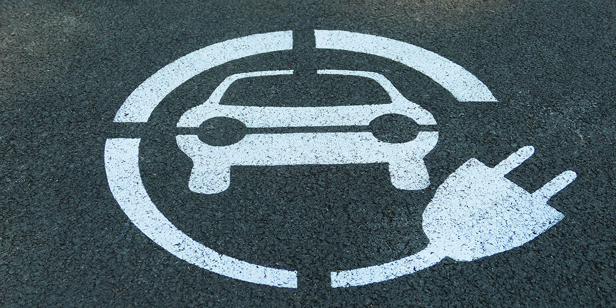 Electric car logo on road