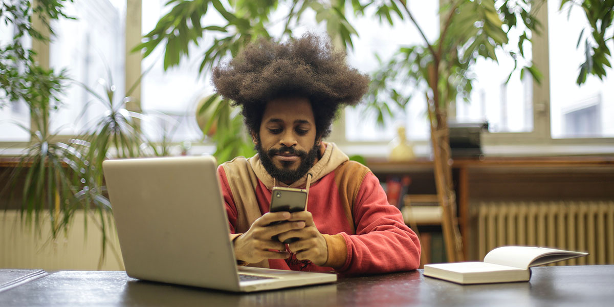 man using his phone to research which electric car to buy