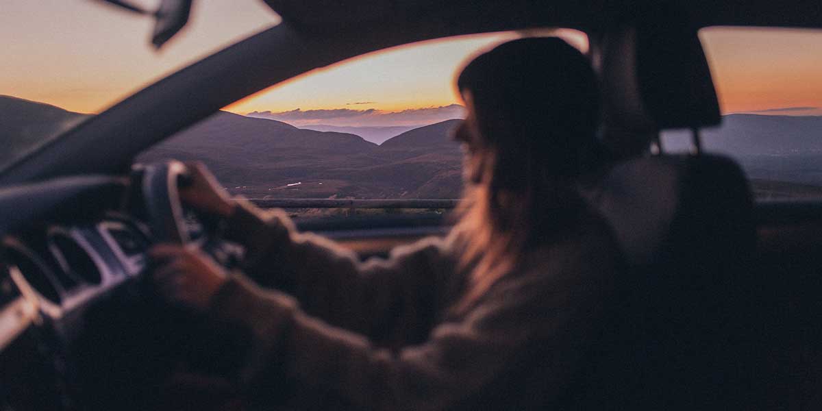 Woman driving at sunset