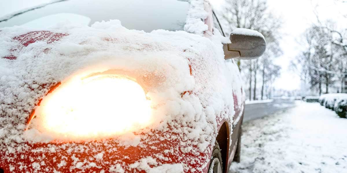 Red car by the road in snow