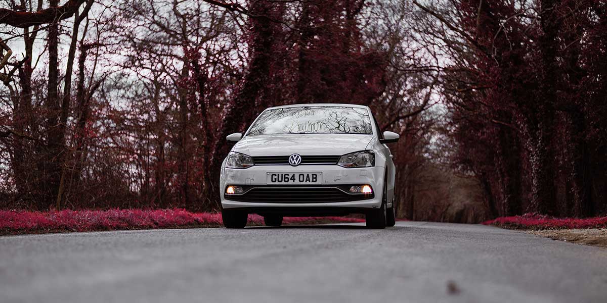 White Volkwagen Polo on country road