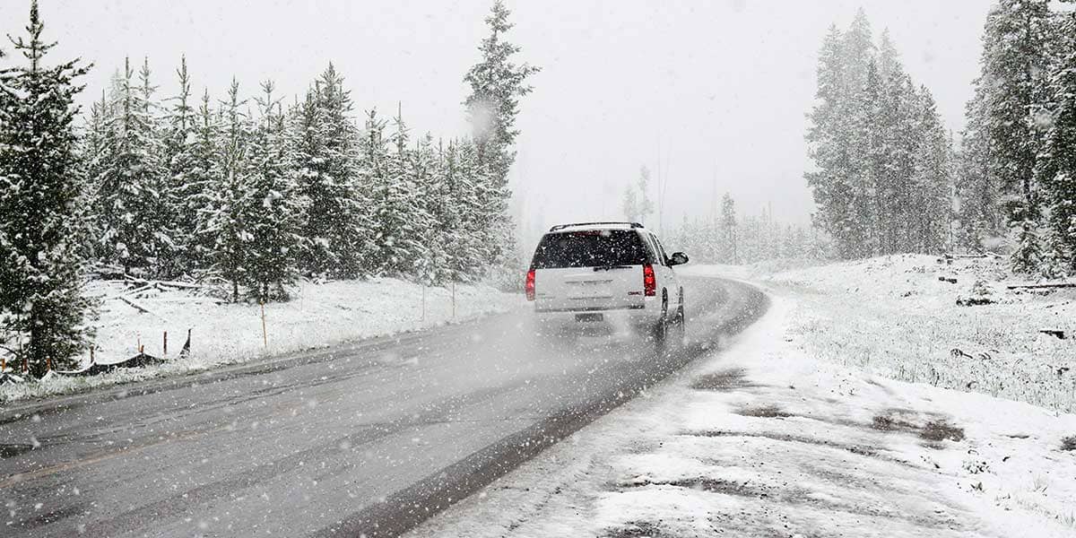 White car driving in the snow