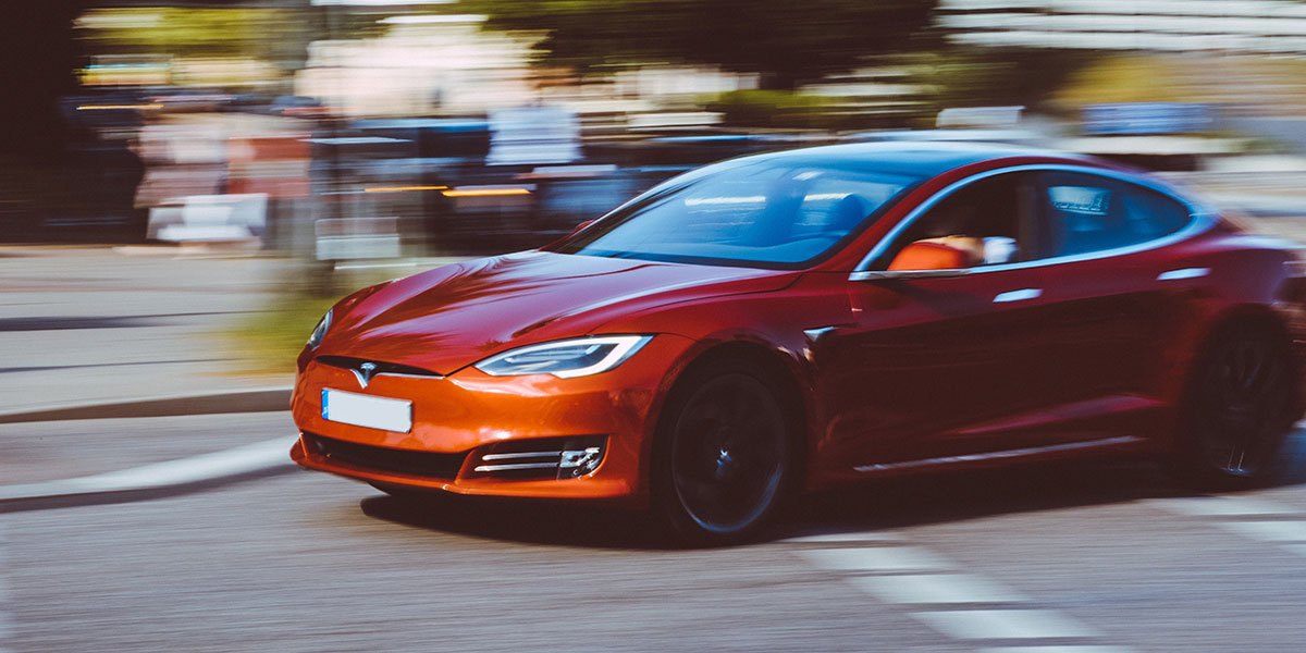 Red Tesla driving through the city