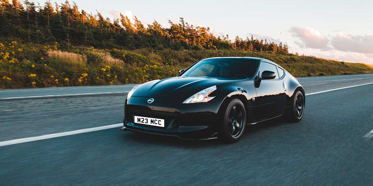 Black sports car driving on road