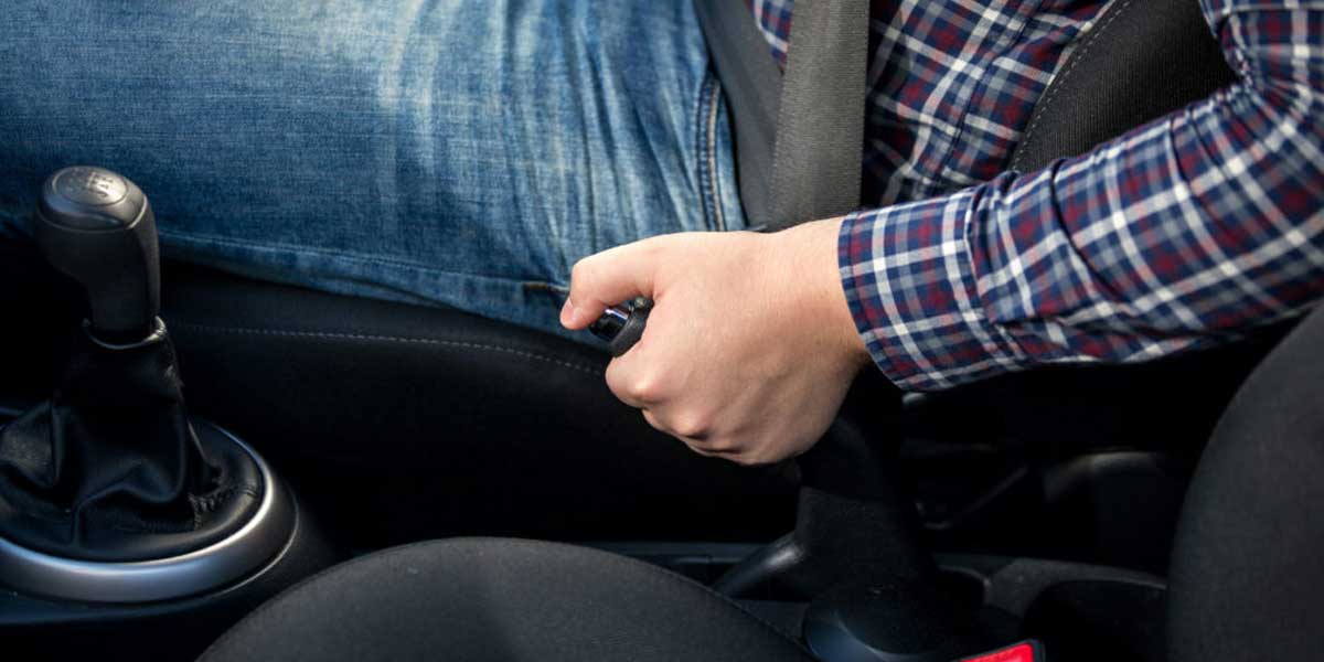 Man releasing a car handbrake
