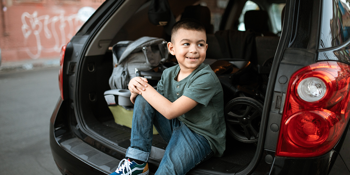 Boy sat in car boot