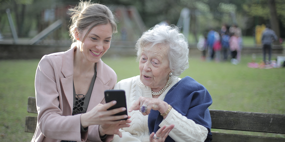 Two people on a bench looking at a phone