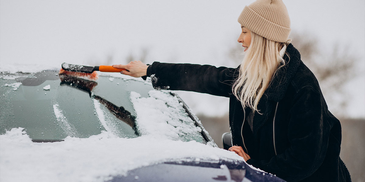 Woman clearing ice from car