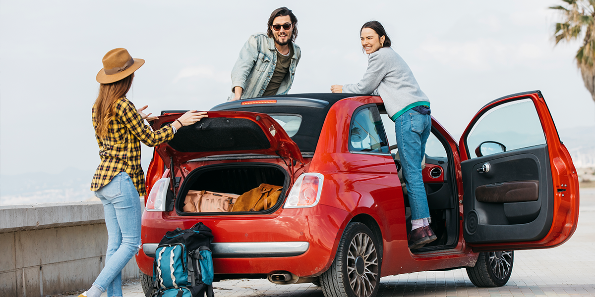 Friends going on a trip in a red car bought using car finance