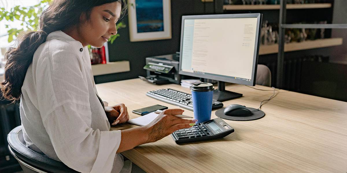 Woman calculating her car repayments on a calculator