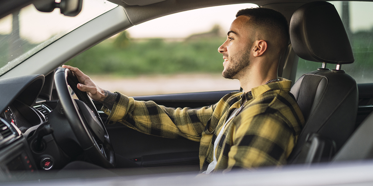 Man driving after figuring out his monthly car payments