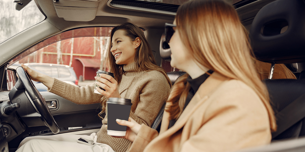 Woman in a car drinking coffee