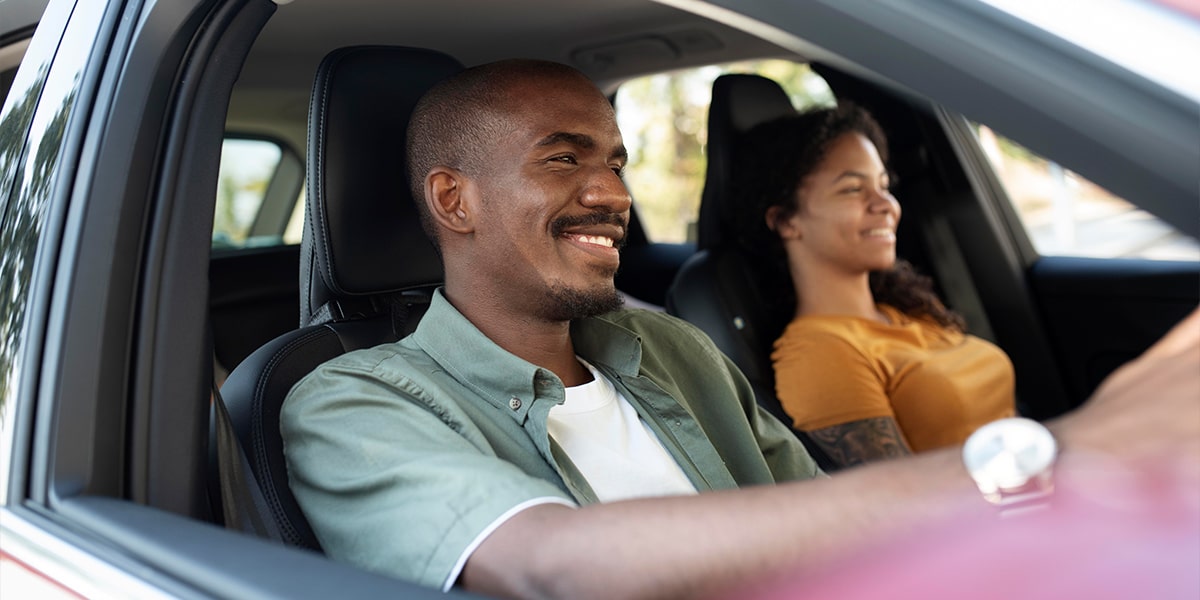Couple driving a new used car