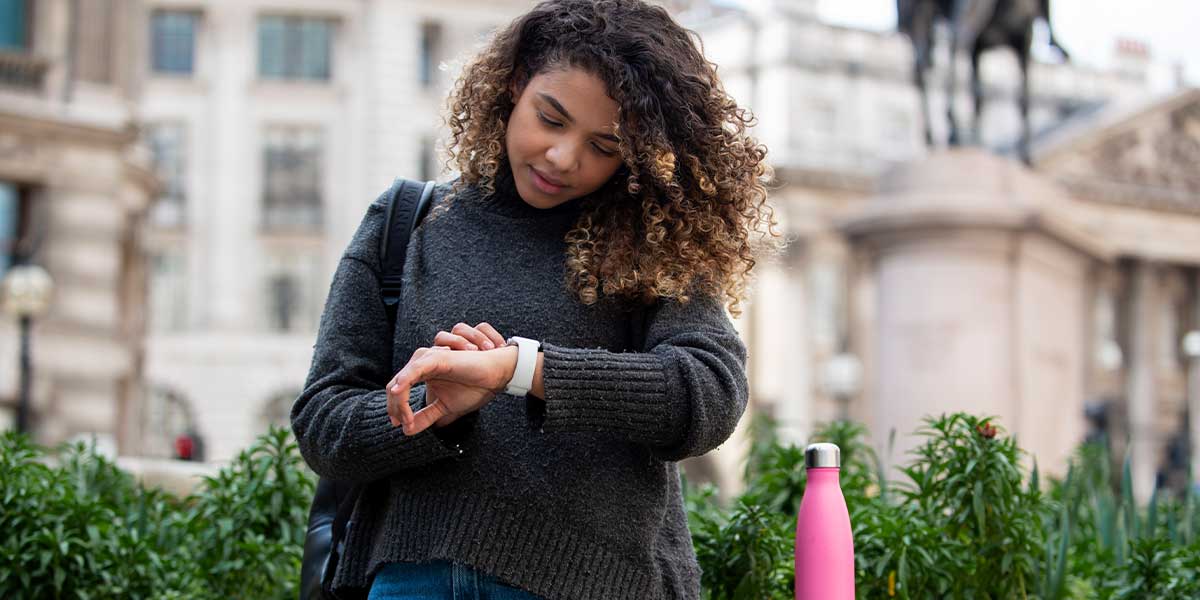 Woman looking at watch in street